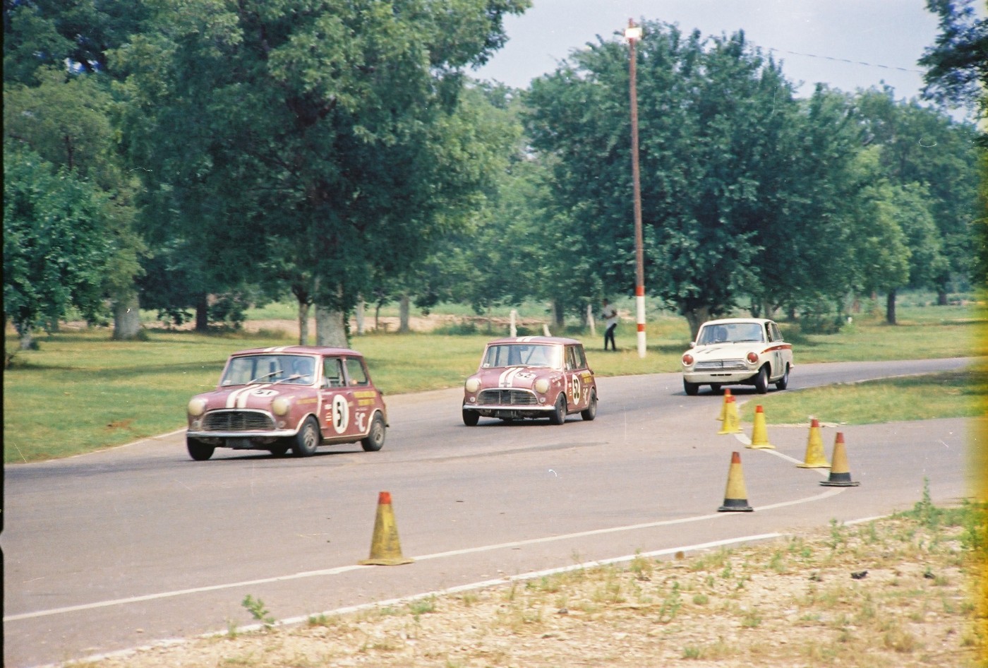 The two Overseas Motors purple Mini-Coopers lead Dave Dooley's B Sedan Lotus Cortina at Green Valley Raceway, Smithfield, Texas, circa 1966.